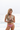 Tracy Anderson stands on a beach, holding her HeartStone Eau de Parfum in her hands.