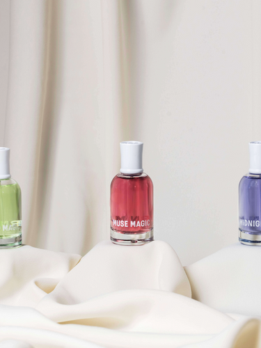The three Evergreen scents from Modern Magic—Melted Magic, Midnight Magic, and Muse Magic—are displayed side by side on individual pedestals.