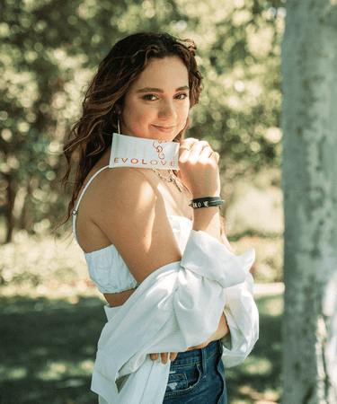Professional dancer, Kaycee Rice, standing outside holding her curl cream for wavy and frizzy hair.