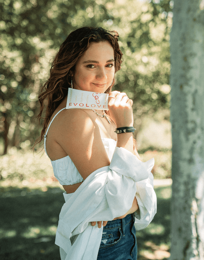 Professional dancer, Kaycee Rice, standing outside holding her curl cream for wavy and frizzy hair.